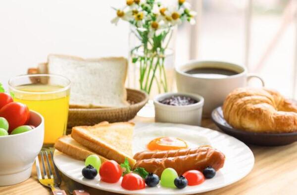 A breakfast scene with toast, fruit, and a hot drink on a wooden table